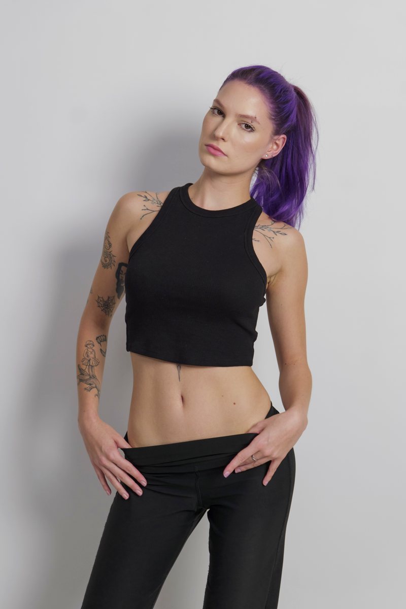 Iulia with a purple ponytail, hands on her hips